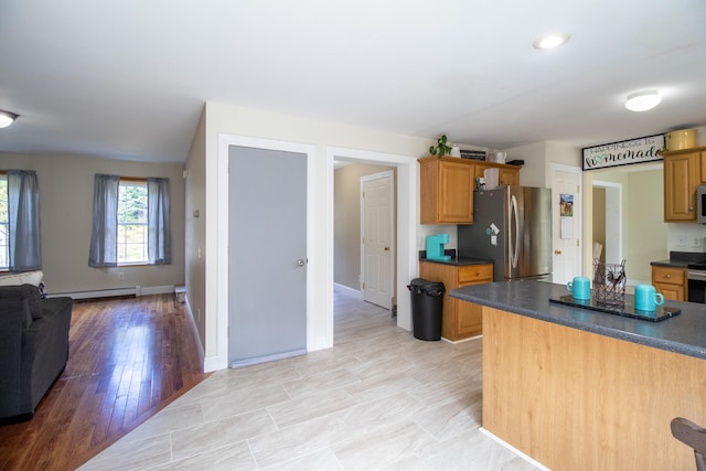 kitchen featuring appliances with stainless steel finishes, light hardwood / wood-style floors, and baseboard heating