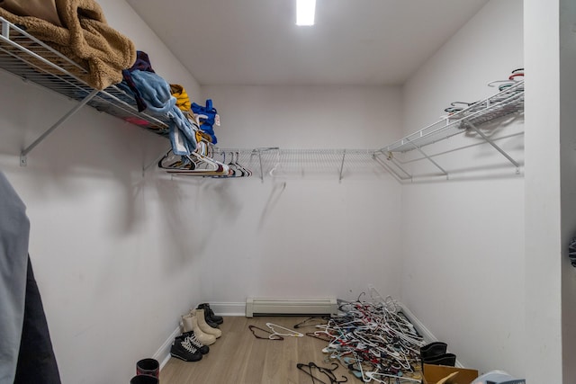 walk in closet featuring baseboard heating and hardwood / wood-style floors