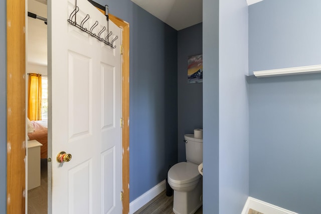 bathroom featuring wood-type flooring and toilet