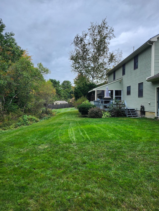 view of yard featuring a wooden deck and a sunroom