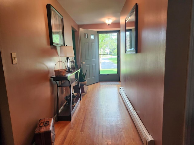 doorway with baseboard heating and light hardwood / wood-style floors