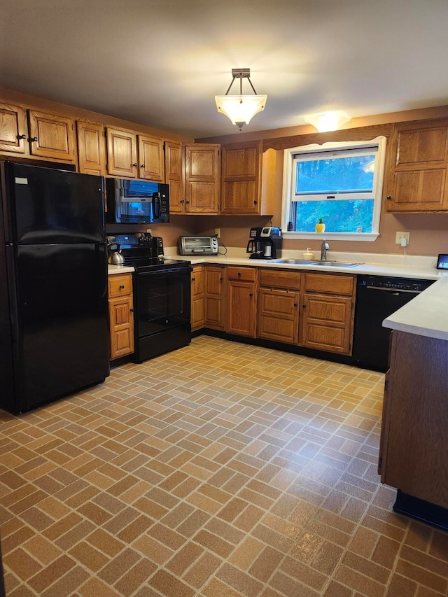 kitchen with black appliances, sink, and pendant lighting