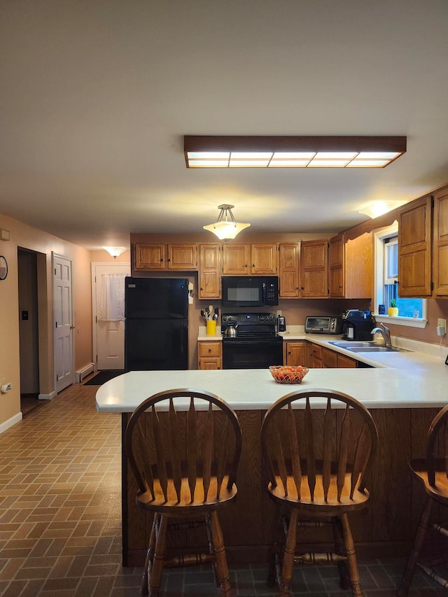 kitchen with a kitchen bar, kitchen peninsula, and black appliances