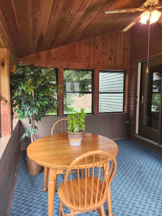 interior space with wooden ceiling, wood walls, vaulted ceiling, and ceiling fan