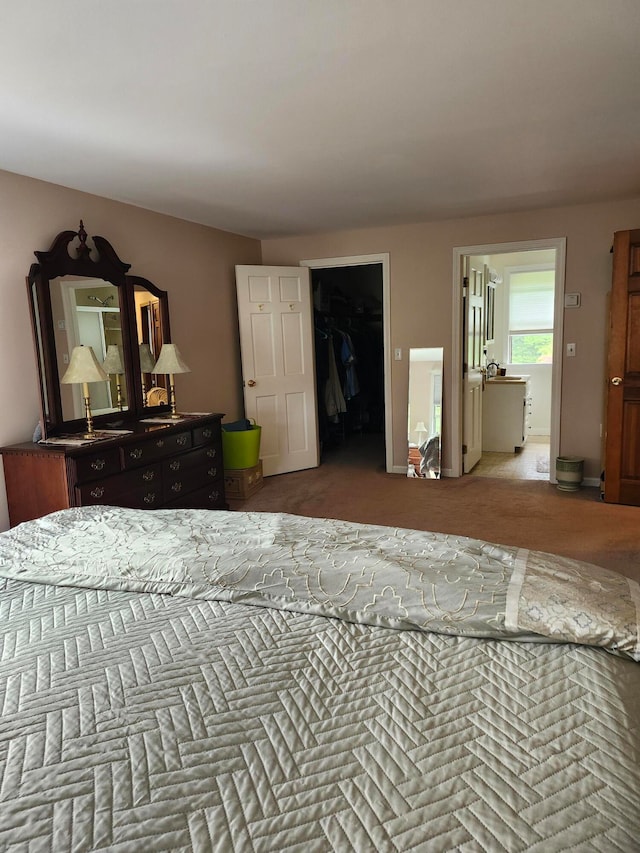 carpeted bedroom with a closet and a walk in closet