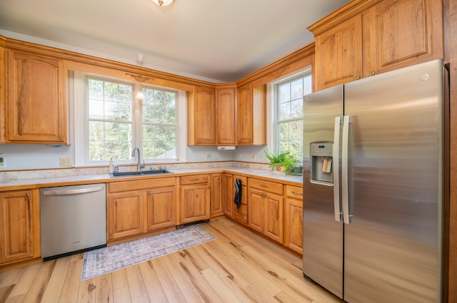 kitchen with appliances with stainless steel finishes, light wood-type flooring, and sink