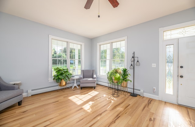 interior space with ceiling fan, baseboard heating, and light hardwood / wood-style floors