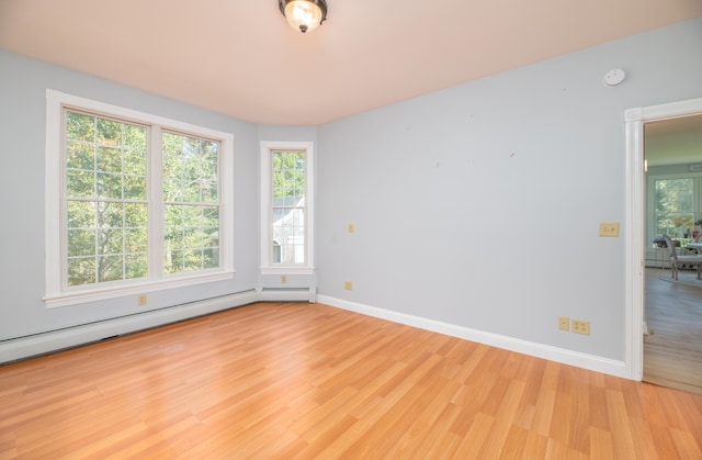 spare room featuring light hardwood / wood-style floors and a baseboard heating unit