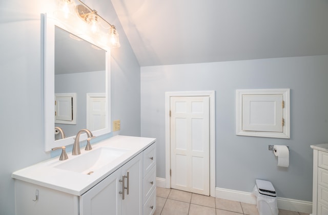 bathroom with vanity, lofted ceiling, and tile patterned flooring