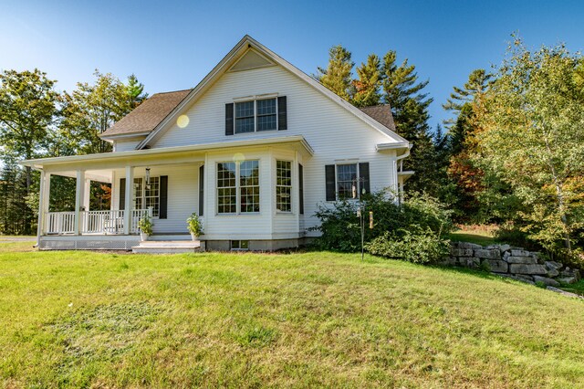 back of property featuring a lawn and covered porch