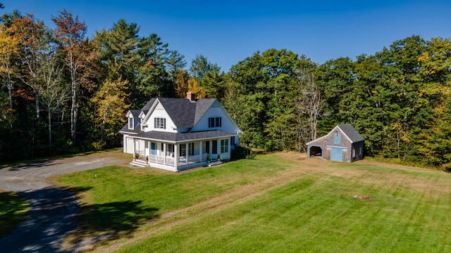 back of house featuring a lawn, an outdoor structure, a porch, and a garage