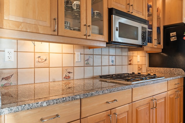 kitchen featuring light stone countertops, stainless steel appliances, and tasteful backsplash