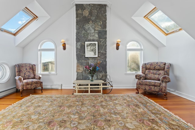 living area with hardwood / wood-style floors, high vaulted ceiling, and a baseboard heating unit