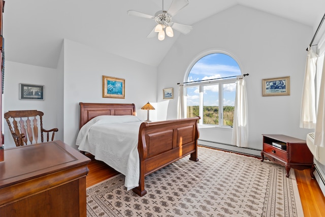 bedroom with ceiling fan, vaulted ceiling, a baseboard radiator, and light hardwood / wood-style flooring