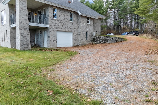 96 Bunker Hill Rd, Newcastle, ME 04553 - view of side of property featuring brick siding, an attached garage, driveway, a balcony, and roof with shingles