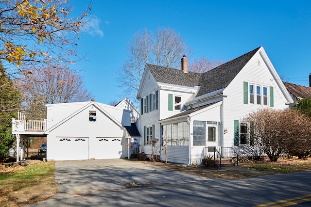 view of side of home with a garage and a sunroom