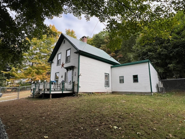 rear view of house with a lawn and a wooden deck