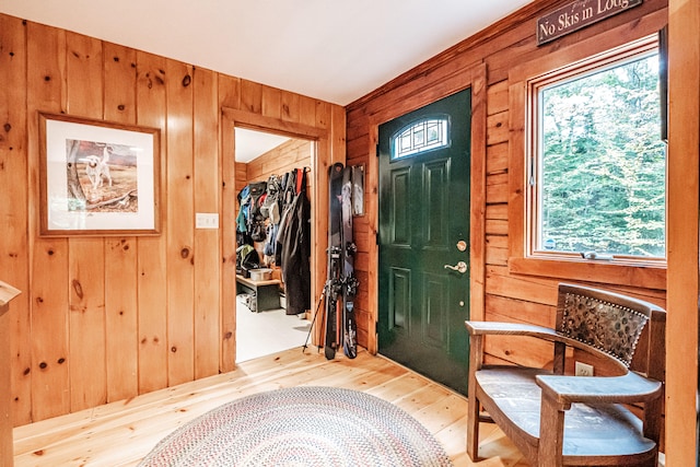 foyer with wooden walls and light hardwood / wood-style flooring