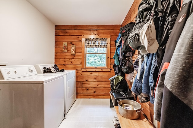 washroom featuring wooden walls and washer and dryer