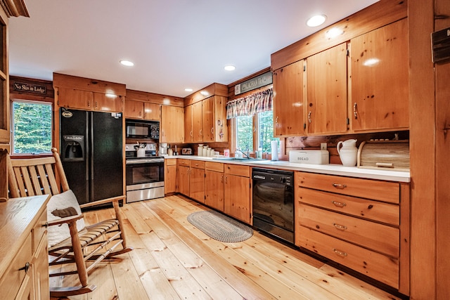 kitchen featuring black appliances, light hardwood / wood-style floors, and sink