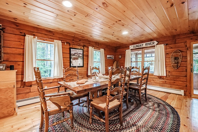 dining area with wooden walls, light hardwood / wood-style floors, a baseboard heating unit, and wooden ceiling