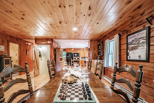 dining room with wooden ceiling, light hardwood / wood-style floors, and wood walls