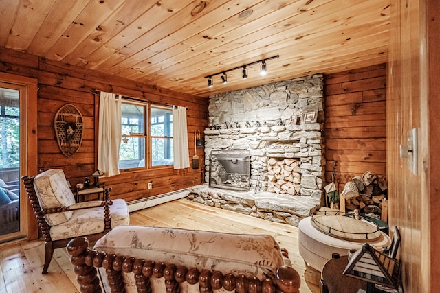 living area featuring wooden ceiling, hardwood / wood-style flooring, a baseboard radiator, and plenty of natural light