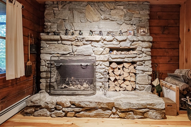 details with wood walls, baseboard heating, hardwood / wood-style flooring, and a fireplace