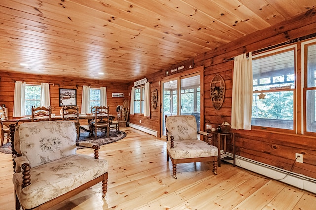 living area featuring light hardwood / wood-style flooring, a baseboard heating unit, wooden ceiling, and wooden walls