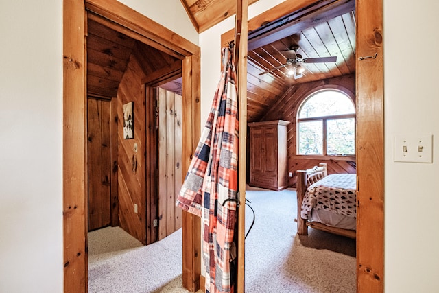 bedroom featuring wooden walls, lofted ceiling, wooden ceiling, and carpet flooring