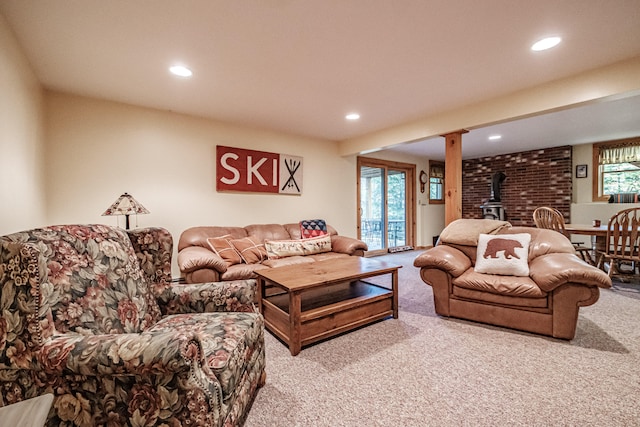 carpeted living room featuring a wood stove and a healthy amount of sunlight