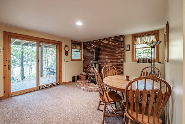 dining room with a wood stove and carpet floors