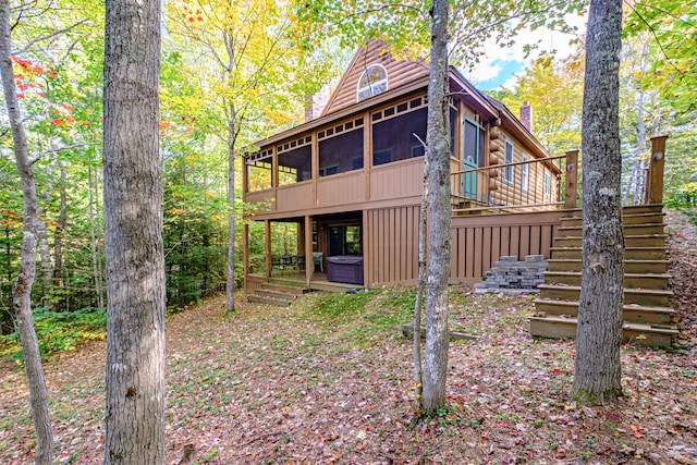 back of house with a wooden deck and a sunroom