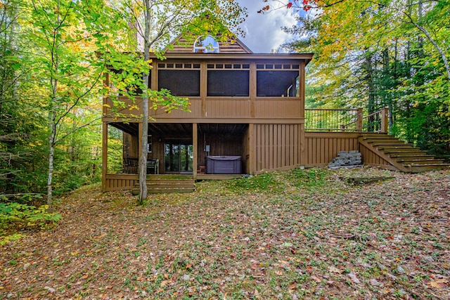 back of property with central AC unit, a sunroom, and a wooden deck