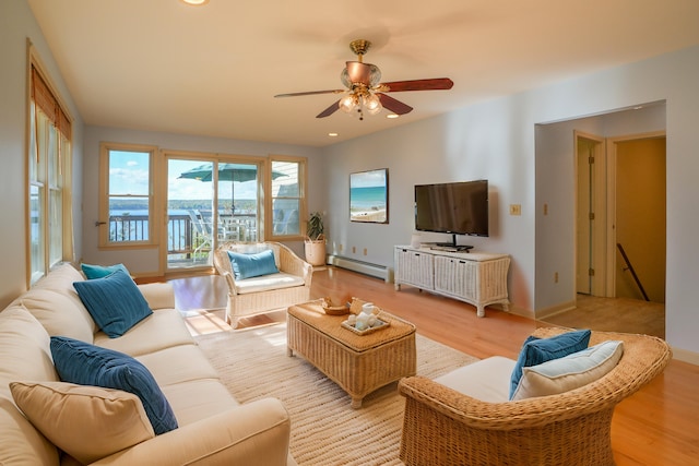 living room with a baseboard heating unit, recessed lighting, baseboards, and light wood finished floors