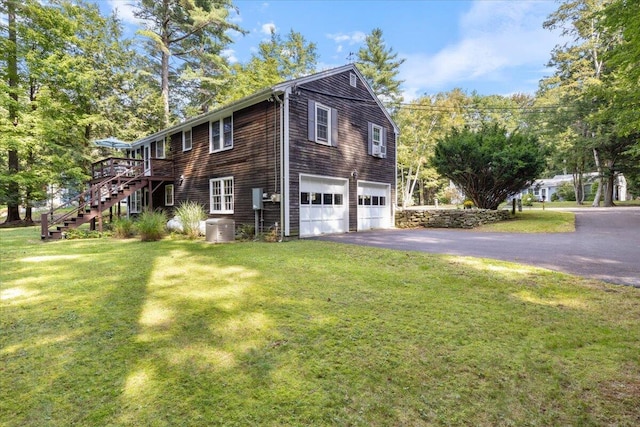 view of side of home featuring a garage, a deck, and a lawn