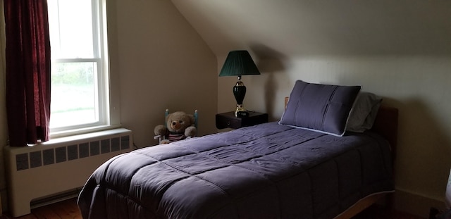 bedroom with wood-type flooring and radiator heating unit