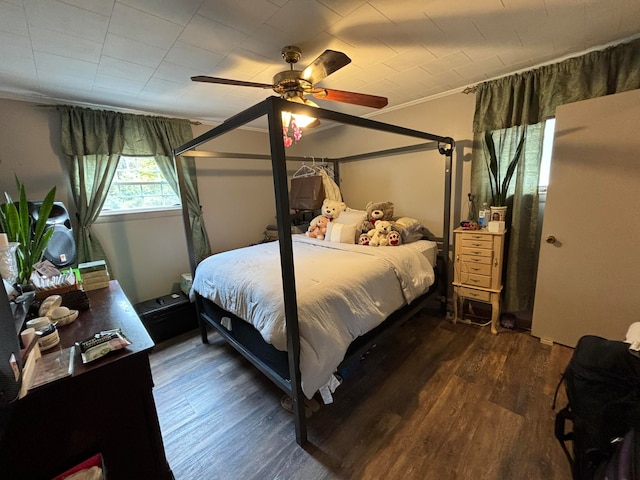 bedroom with dark hardwood / wood-style flooring and ceiling fan