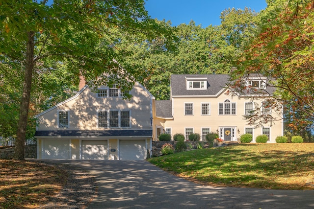 view of front of property with a garage and a front lawn