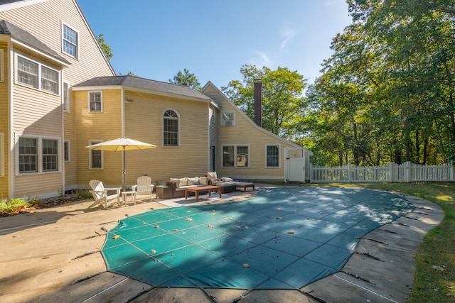 back of house featuring an outdoor hangout area, a covered pool, and a patio area