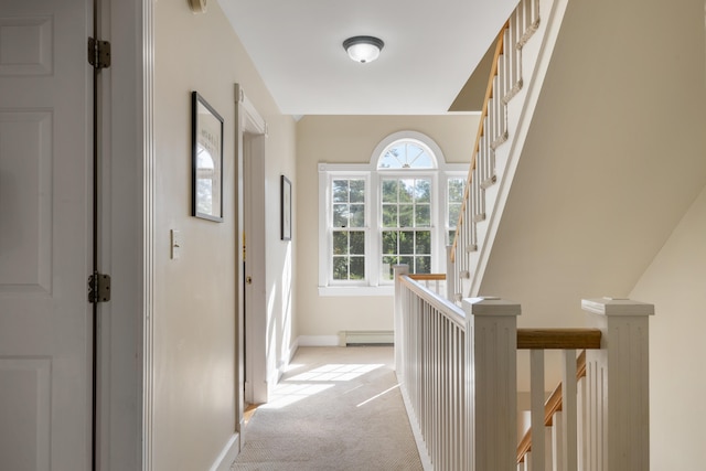 corridor featuring light colored carpet and a baseboard radiator