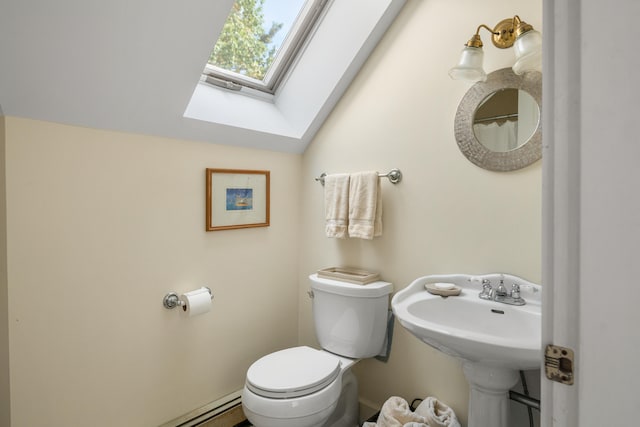 bathroom featuring vaulted ceiling with skylight and toilet