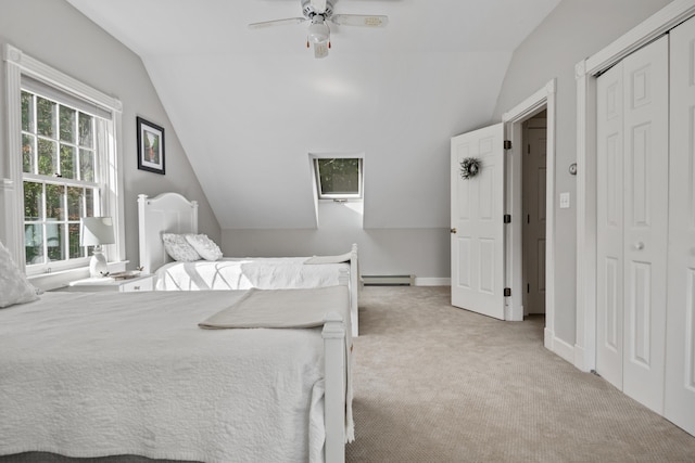 carpeted bedroom with a baseboard radiator, a closet, lofted ceiling, and ceiling fan