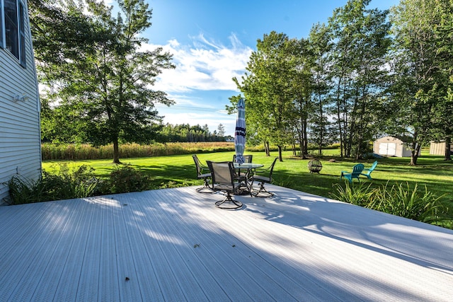 wooden terrace featuring a yard and a shed