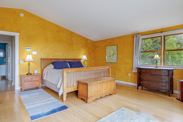 bedroom with vaulted ceiling and light hardwood / wood-style floors