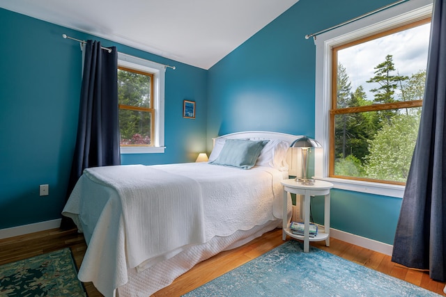 bedroom featuring hardwood / wood-style flooring and vaulted ceiling