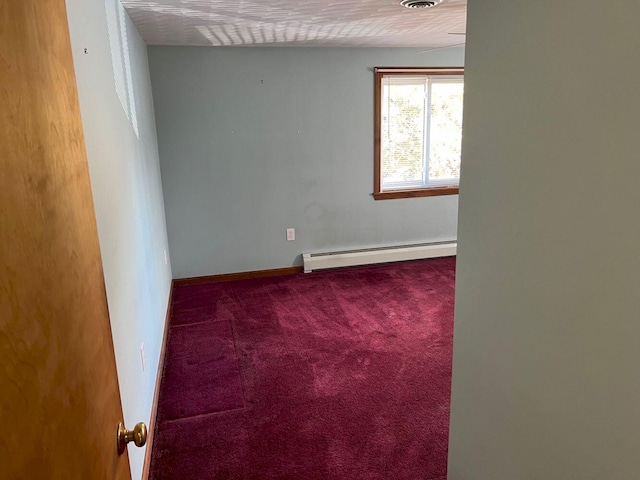 carpeted spare room featuring a baseboard radiator