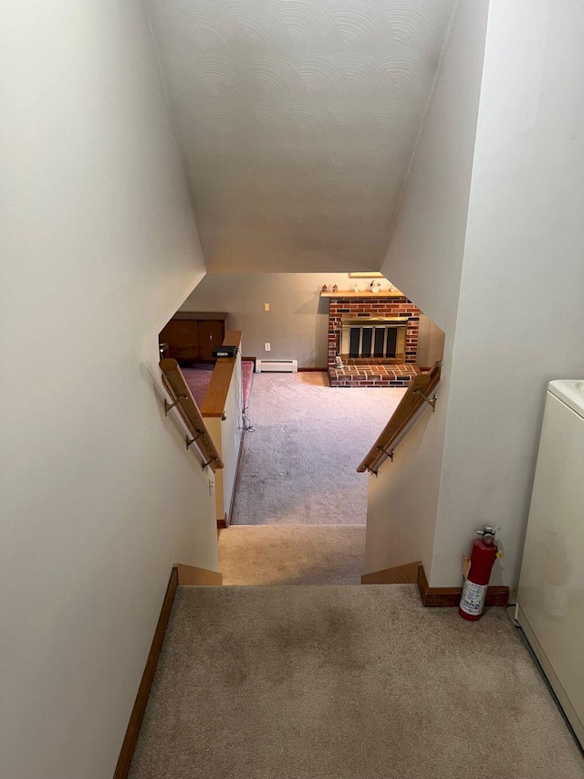 staircase featuring carpet flooring, a baseboard radiator, vaulted ceiling, and washer / dryer