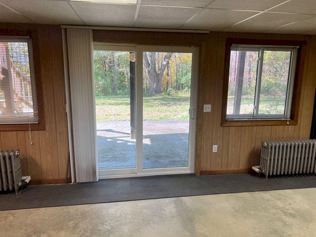 doorway to outside featuring wood walls and radiator