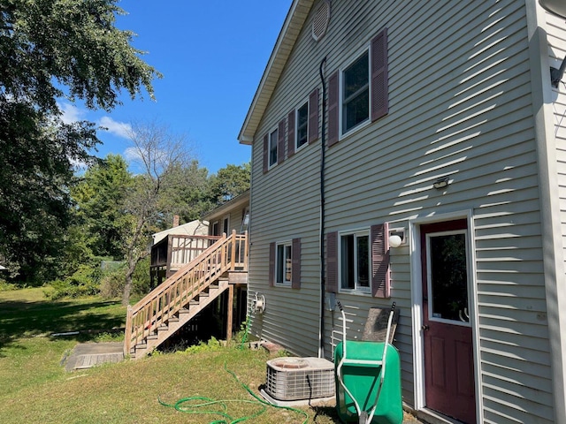 exterior space featuring central air condition unit, a yard, and a deck